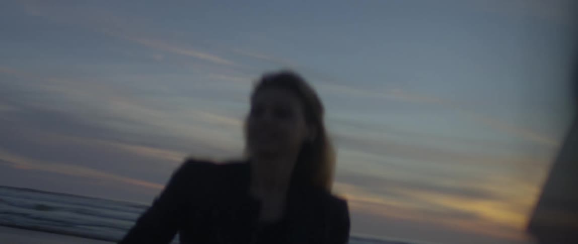 A woman is photographing the beach at dawn