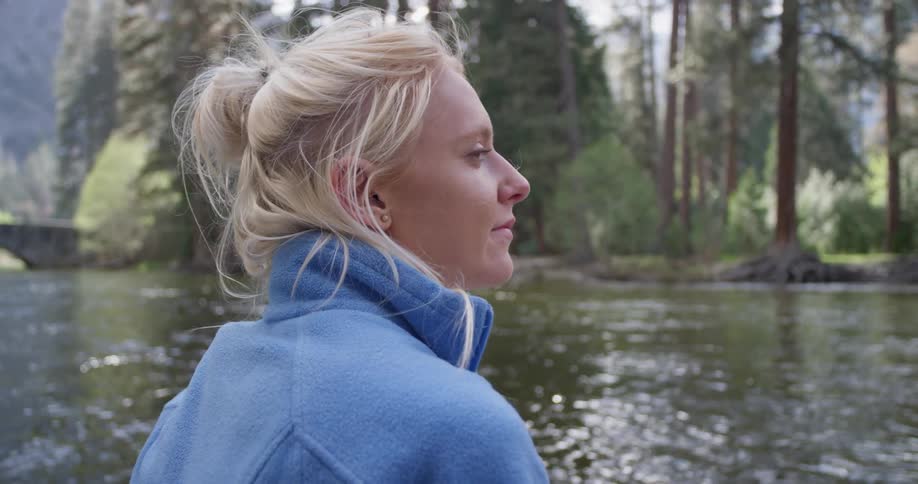 A woman looks around by the flowing river waters