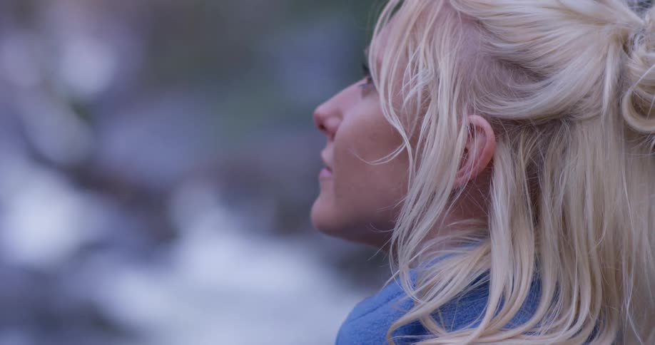 Woman stands in nature looking around