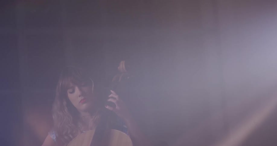 A woman sits and plays the cello