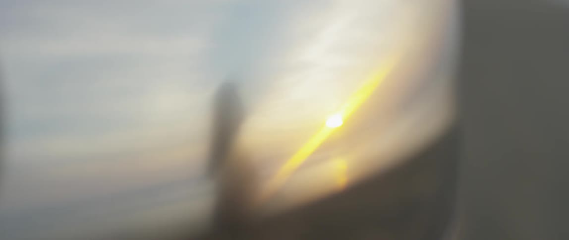 The reflection of a woman walking at sunset