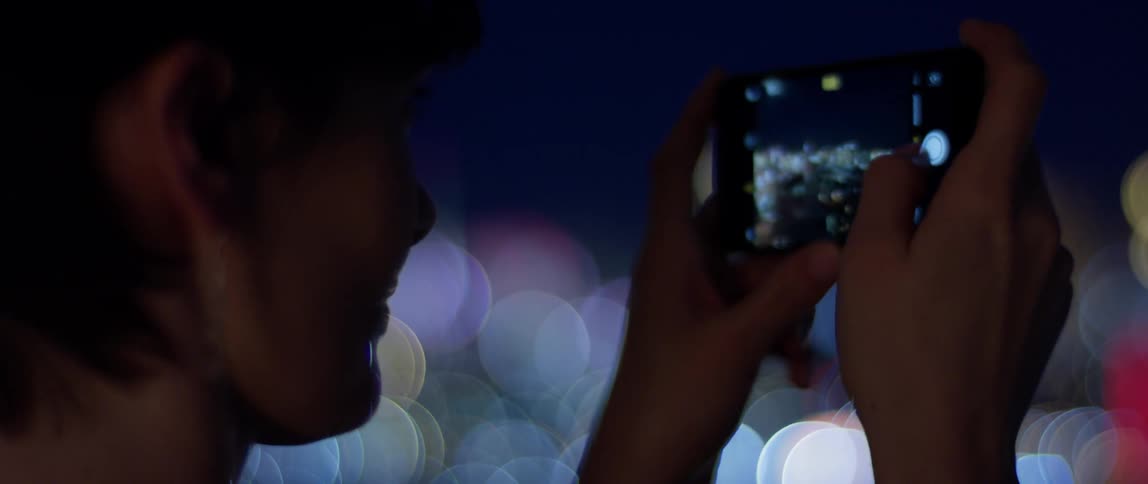 Woman takes a picture of the city at night