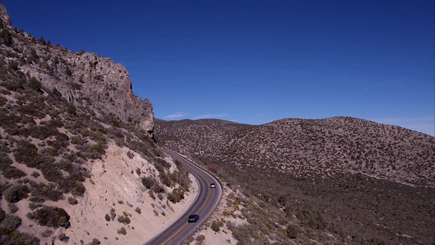 Cars travel on a remote mountain road