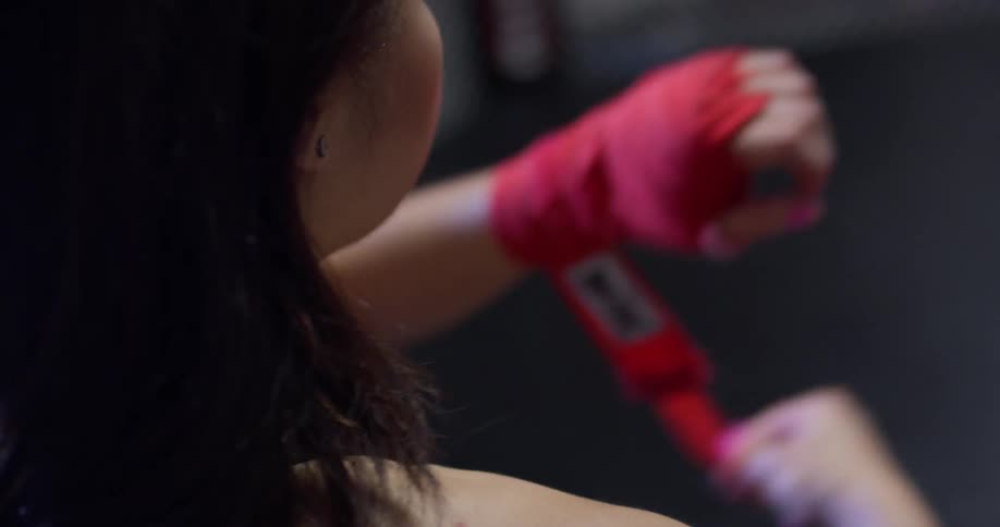 A woman unwraps athletic tape from her hands