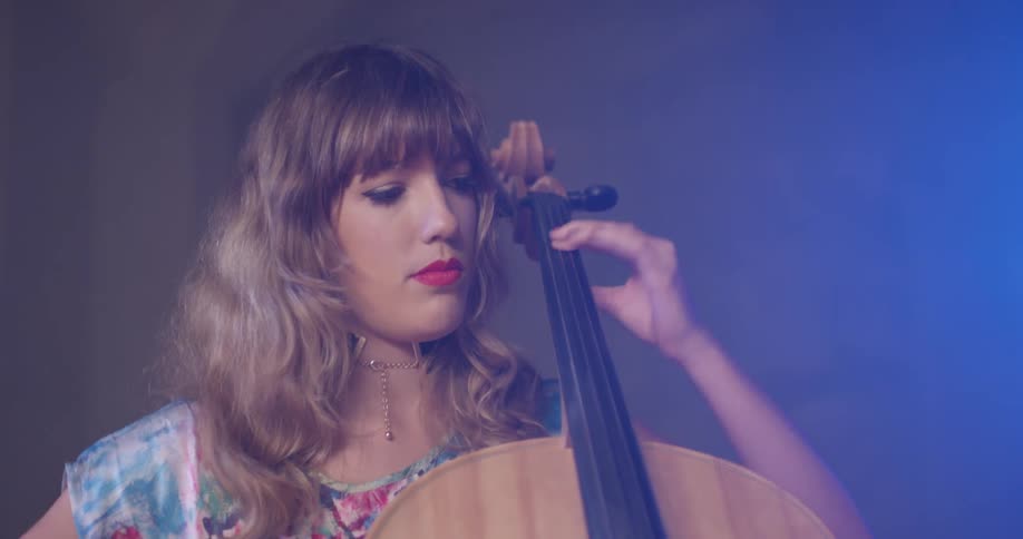 A woman sits and plays the cello
