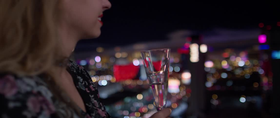 A woman drinks champagne in las vegas at night