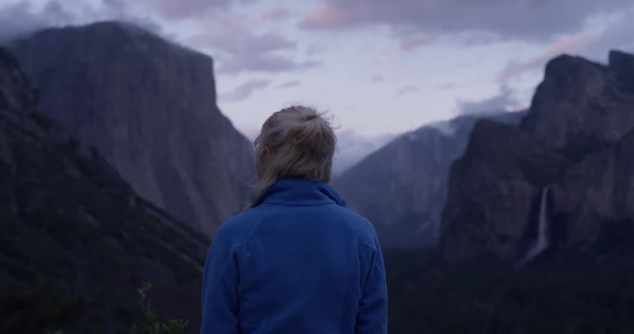 A woman looks out towards the mountains