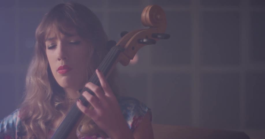 Woman is sitting with eyes closed while playing the cello