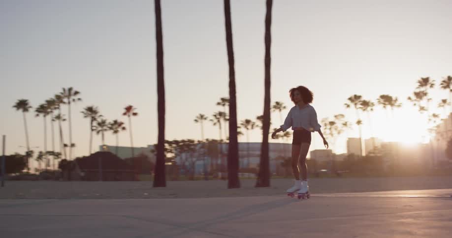 Woman skates on a sidewalk near the city