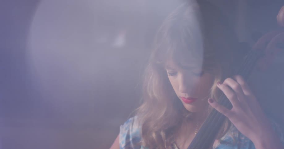 A woman is playing the double bass in the dark room