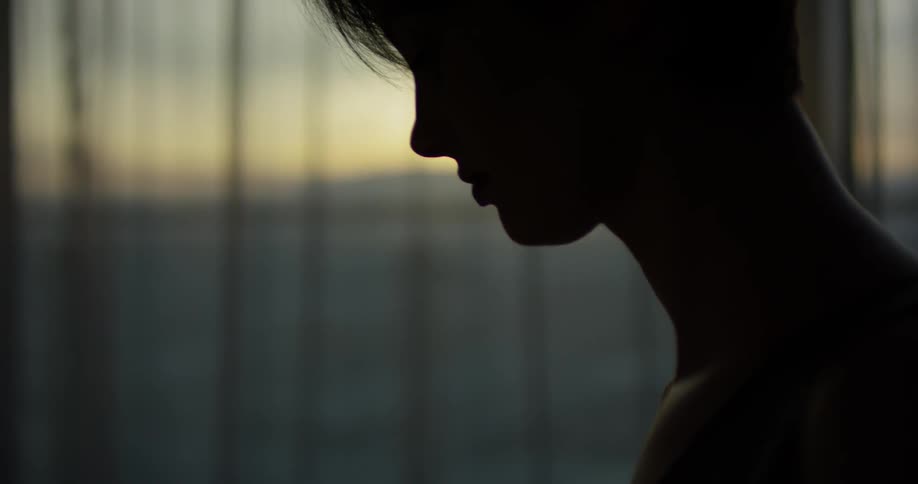 A woman leans forward at dawn