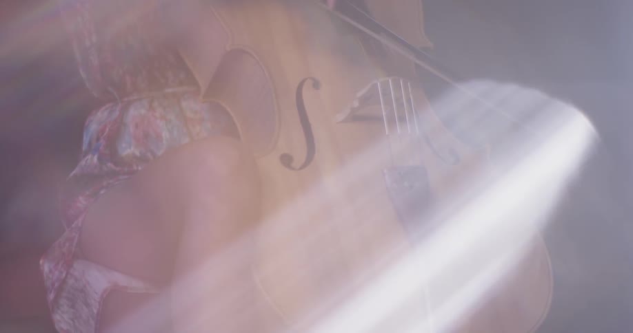 A person sits playing the double bass