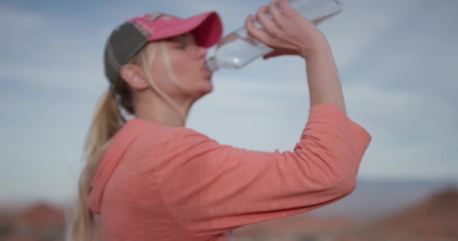 A woman stops and takes a drink of water