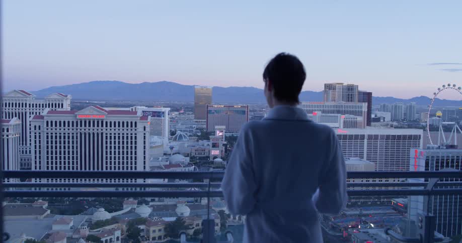 A woman is looking out over the city from her balcony