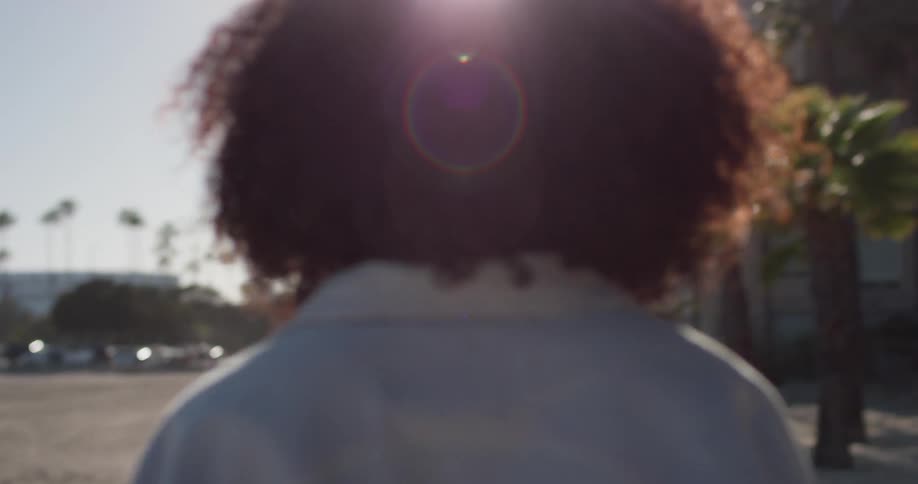 A woman walks outside on a sunny day