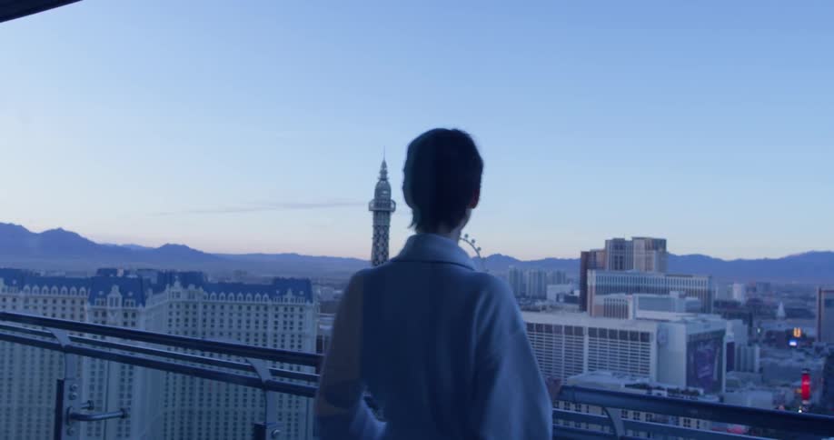 A woman is looking at a tower from her balcony