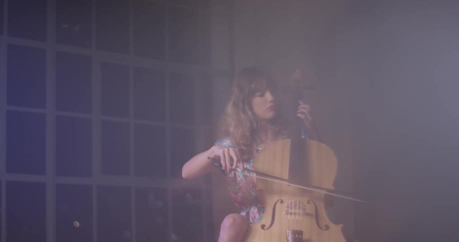 A woman sits and plays the cello