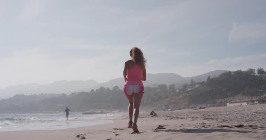 A woman jogs on the beach