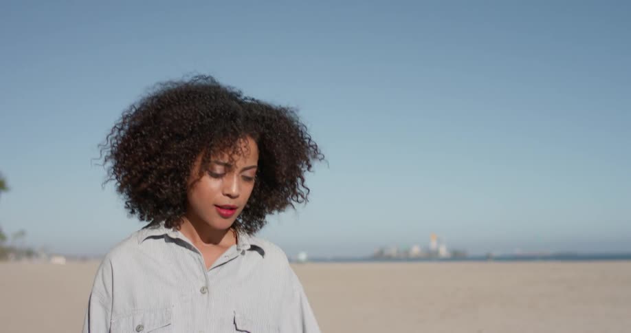 Woman is walking on beach on sunny day