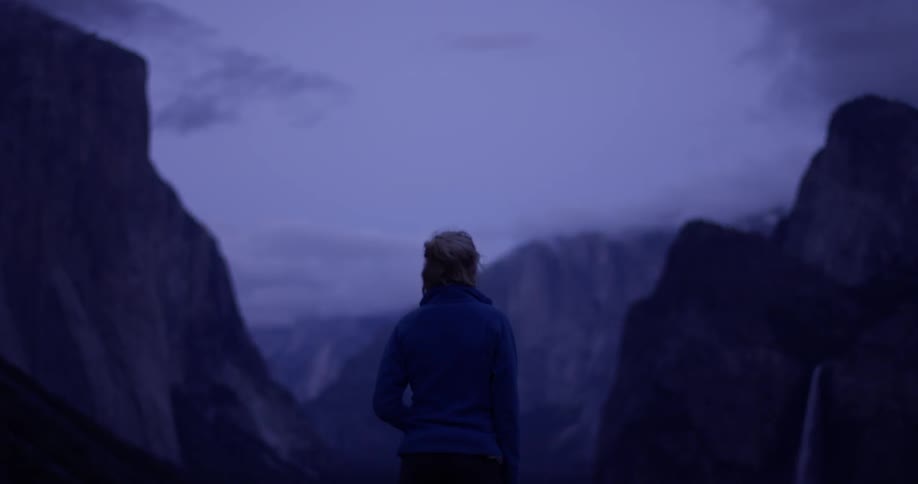 A person watches the mountains covered with clouds