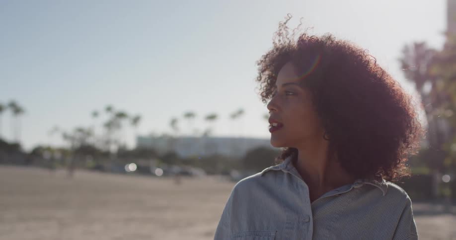 A woman stands outside on a sunny day