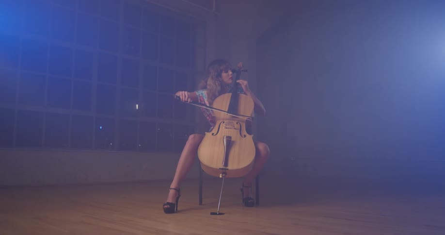 Woman plays cello in a large empty room