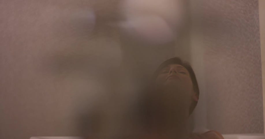 Woman sits in a bathtub bathing herself