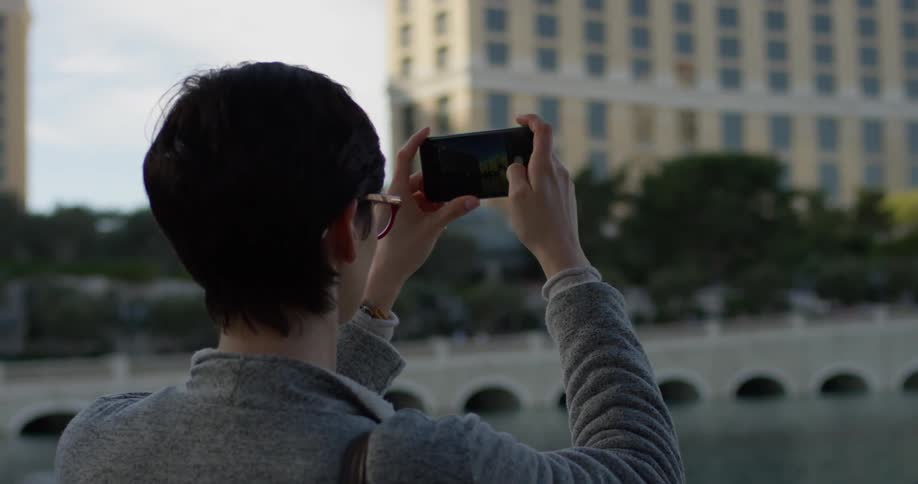 A woman takes photos with her cell phone