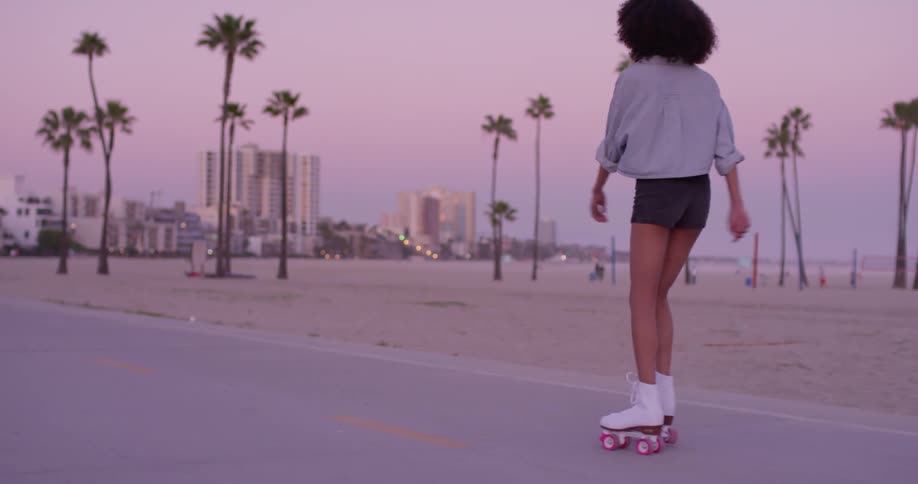 A woman roller skates near the beach