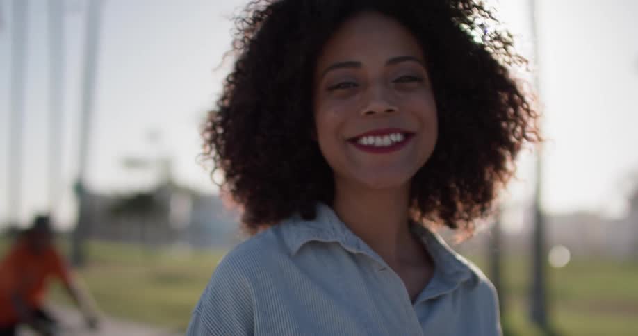 A woman smiles and walks near the palm trees
