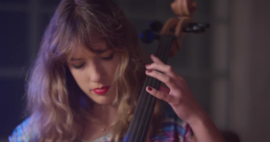 Woman plays a cello with her eyes closed