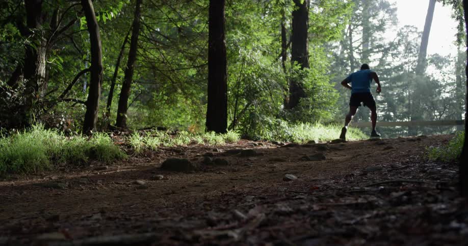 A man runs over the rocks near the forest