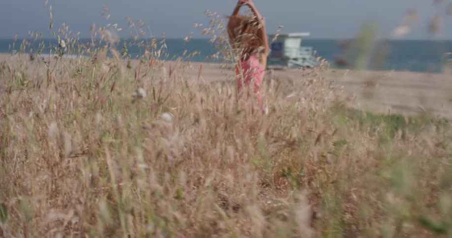 Woman jogs in place stretching her arms on the beach