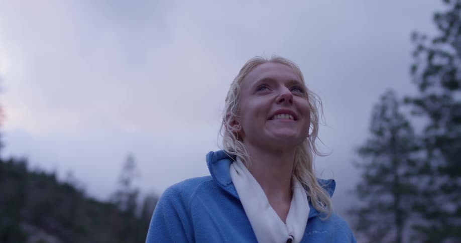 A woman hikes in a forest at sunset