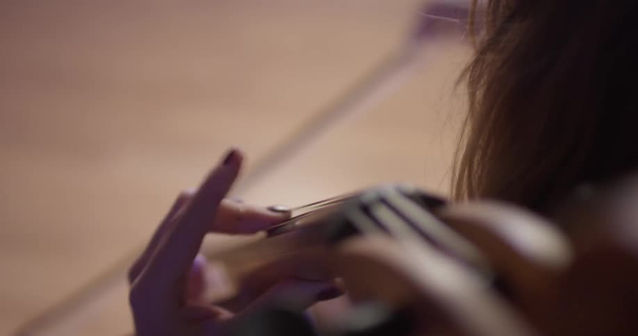 A woman is playing a bass inside in daylight