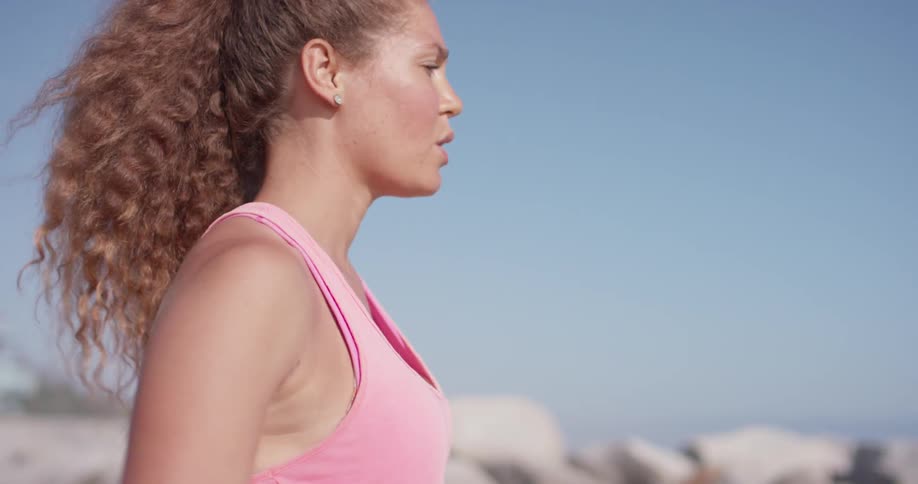 A woman stretches outside on a sunny day