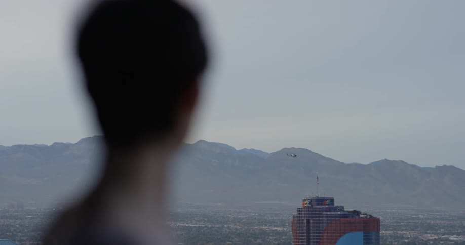 Woman stands on a balcony overlooking the city