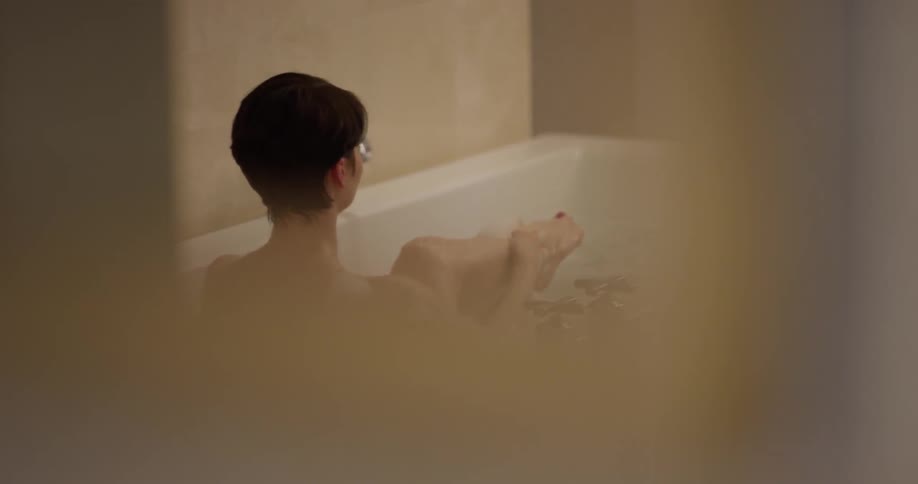 Woman bathes herself in a large tub