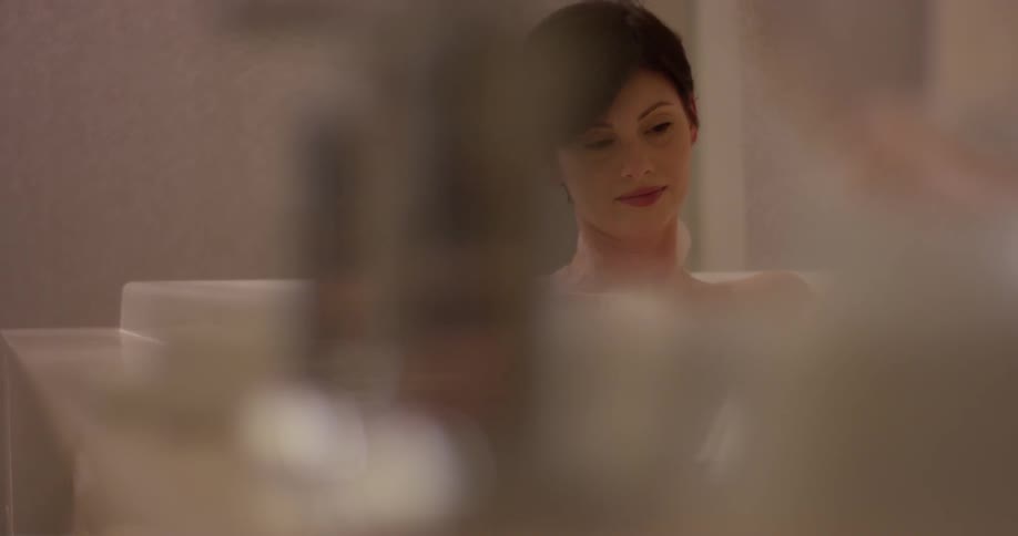 Woman sits in a bathtub