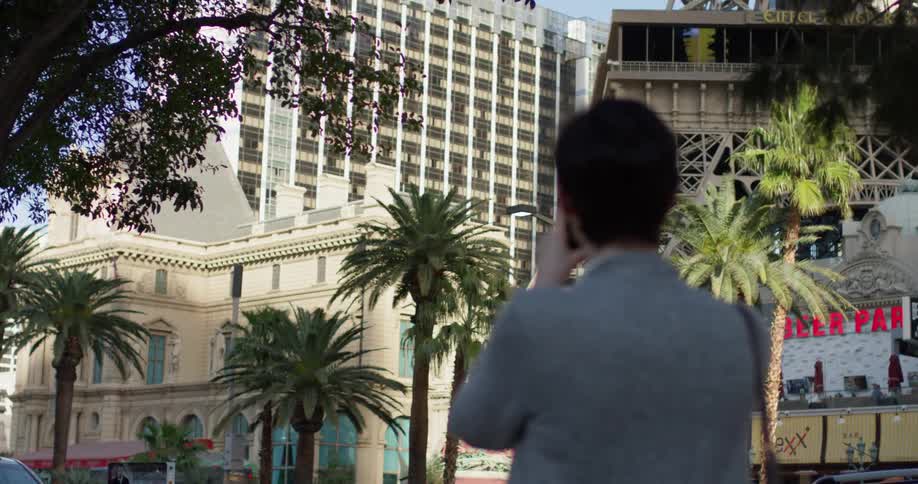 A woman is photographing the large building in front of her