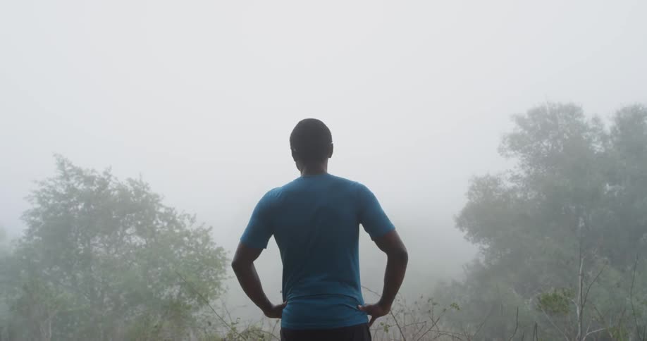 A man watches the woods covered in fog