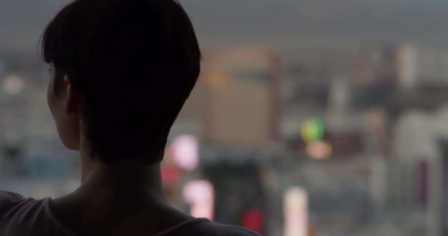 Woman looks out at the buildings in the city