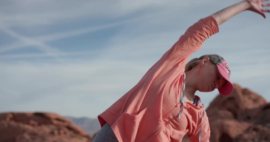 A woman stretches in a desert