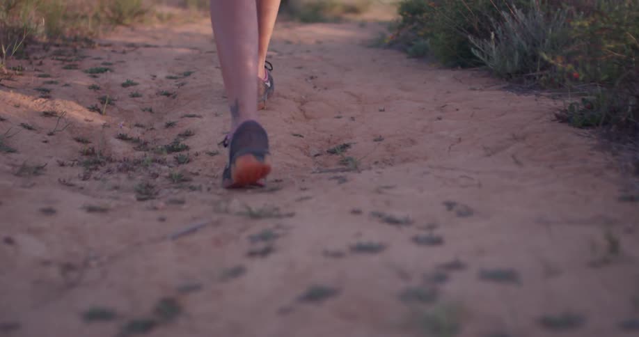 A woman walks on a rural dirt path