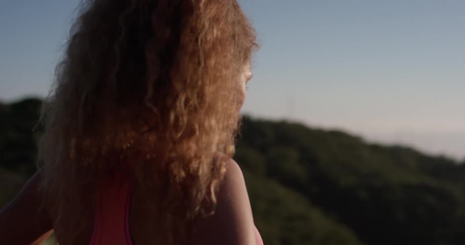 A woman hikes in mountains on a sunny day