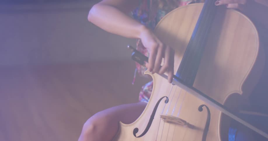 A woman sits and plays the cello