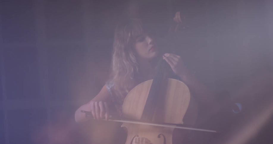 A woman sits and plays the cello