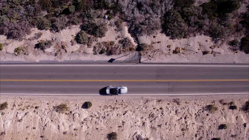 The car drives down the highway below