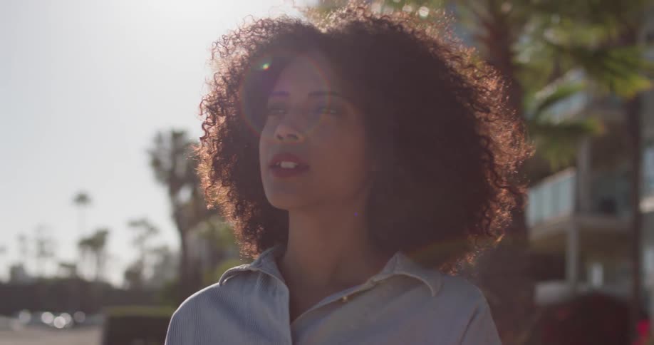 A woman stands outside in the breeze