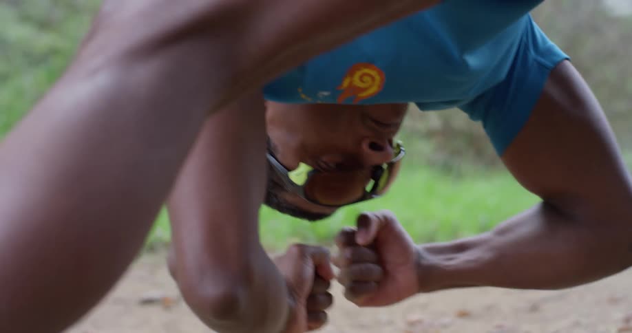 A man stretches outside on a dirt trail